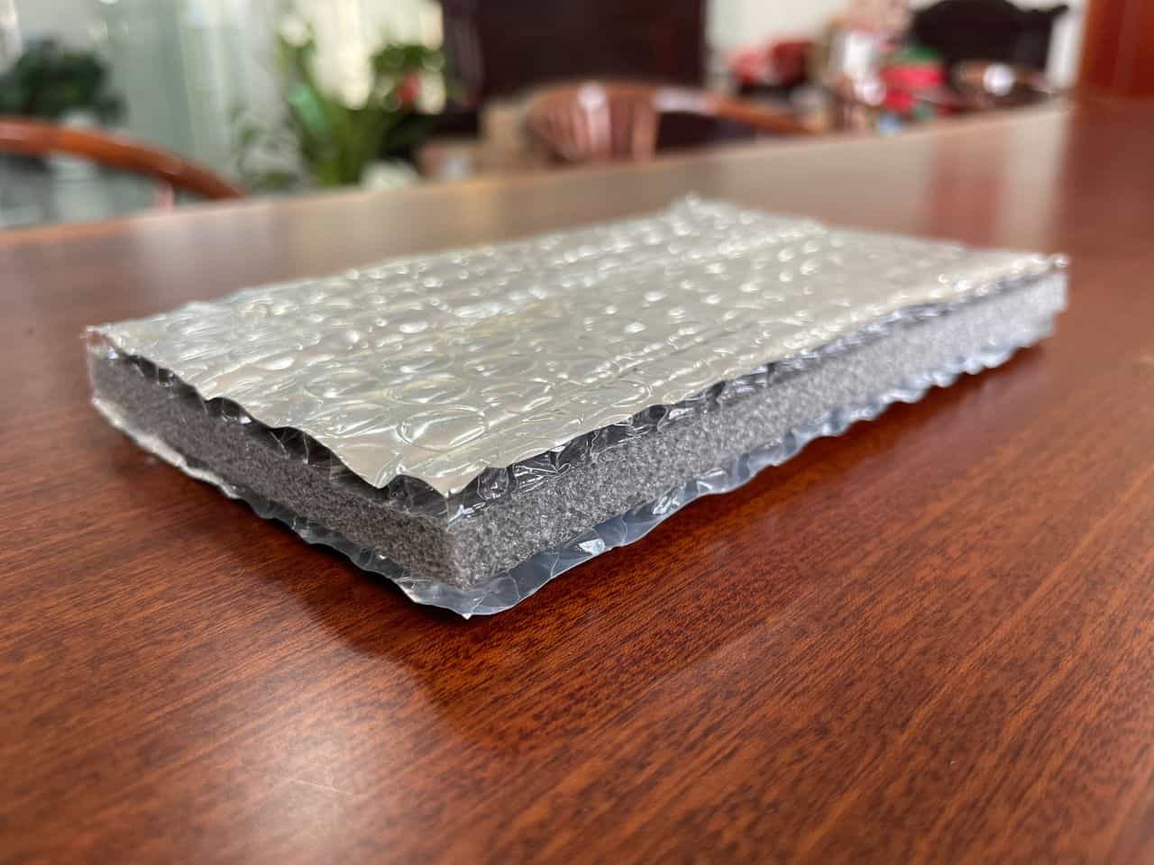 Highly insulating insulated wall panel with bubble wrap and foam core for thermal comfort and soundproofing. Ideal for residential and commercial insulation solutions.